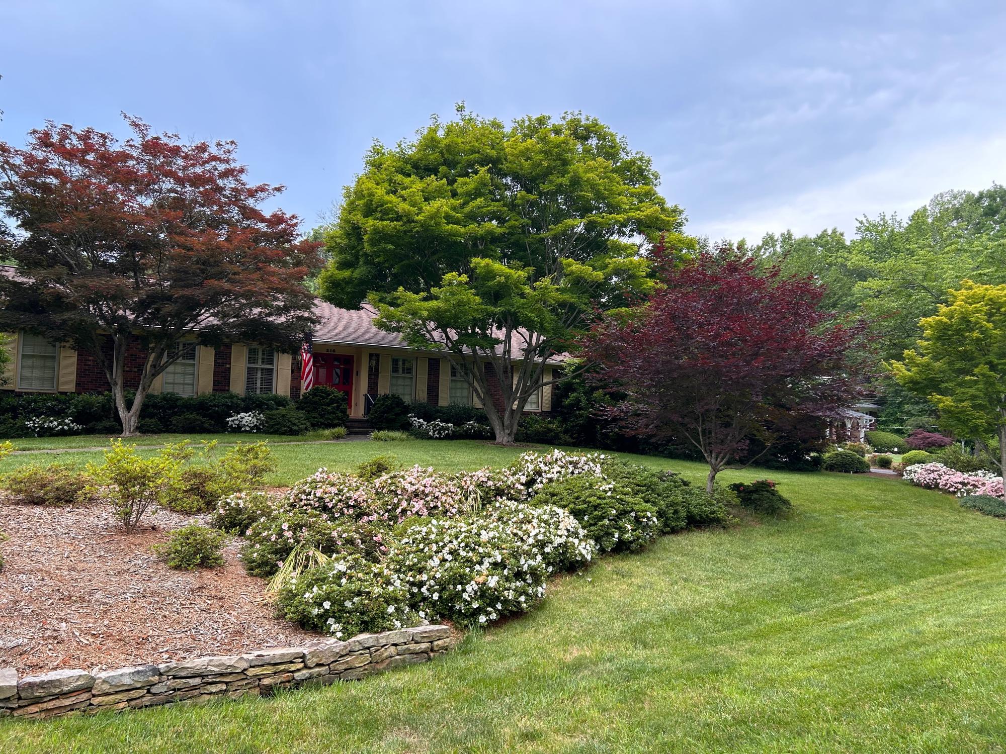 Manicured lawn with colorful flowers and trees